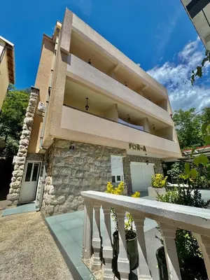 a large building with a staircase in front of it at FOR-A Apartmani in Becici