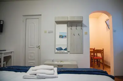 a bedroom with a bed and a mirror and a table at FOR-A Apartmani in Becici