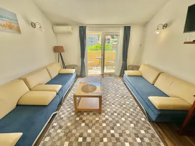 a living room with a couch and a table at FOR-A Apartmani in Becici