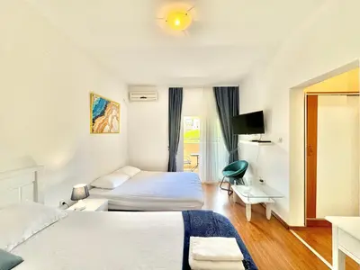 a hotel room with two beds and a desk at FOR-A Apartmani in Becici