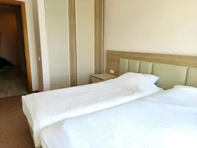two beds in a bedroom with white sheets at Skyline View Apt & Pool Retreat in Budva