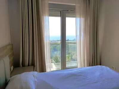 a bedroom with a bed and a large window at Skyline View Apt & Pool Retreat in Budva