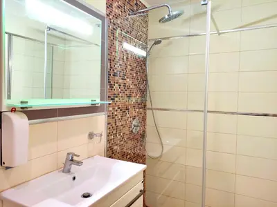 a bathroom with a sink and a shower at Skyline View Apt & Pool Retreat in Budva
