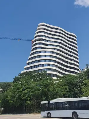 a bus parked in front of a tall building at Skyline resort in Becici