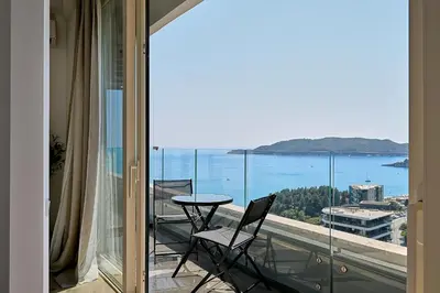 a balcony with a table and chairs and a view of the ocean at Skyline resort in Becici