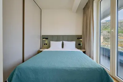 a bedroom with a bed and a large window at Skyline resort in Becici