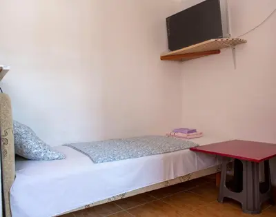 a small bedroom with a bed and a flat screen tv at Villa Horizon Canj in Čanj