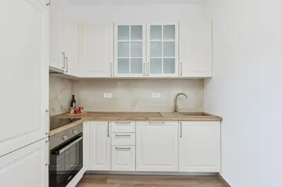 a white kitchen with white cabinets and a sink at Stanisic Family Apartments in Kotor