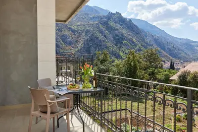 a balcony with a table with a view of a mountain at Stanisic Family Apartments in Kotor