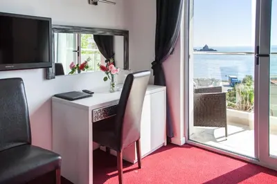 a room with a desk with a view of the ocean at Vile Oliva Hotel & Resort in Petrovac na Moru