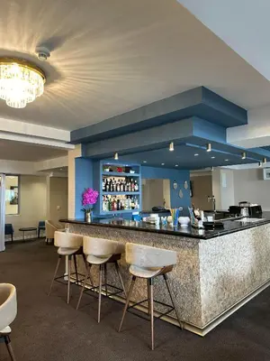 a lobby with a bar with stools at Vile Oliva Hotel & Resort in Petrovac na Moru