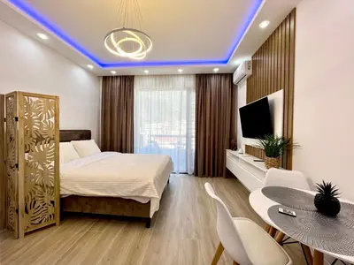 a bedroom with a bed and a table and chairs at Luxury apartment Casa Al Mare in Rafailovici