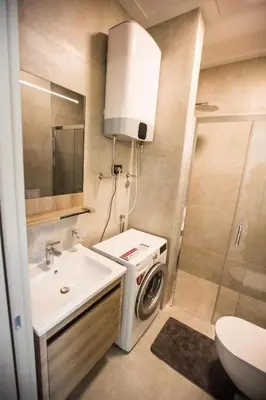 a bathroom with a sink and a washing machine at Luxury apartment Casa Al Mare in Rafailovici