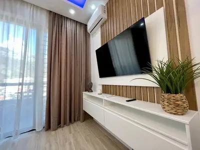 a living room with a television on a wall at Luxury apartment Casa Al Mare in Rafailovici