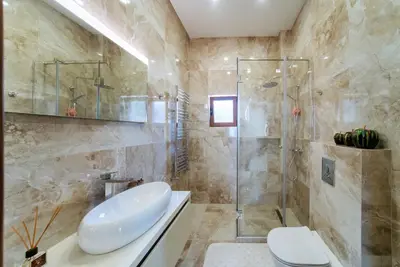 a bathroom with a shower and a toilet and a sink at Cape Montenegro Villas in Krimovice