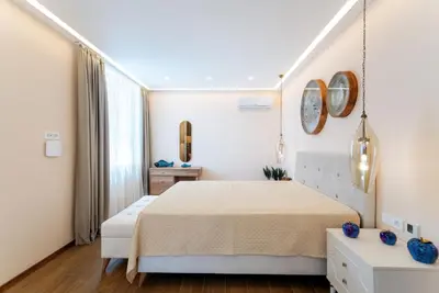 a white bedroom with a bed and a window at Cape Montenegro Villas in Krimovice