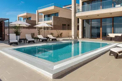 a swimming pool in front of a building at Cape Montenegro Villas in Krimovice