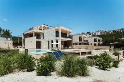 a house on the beach with a swimming pool at Cape Montenegro Villas in Krimovice