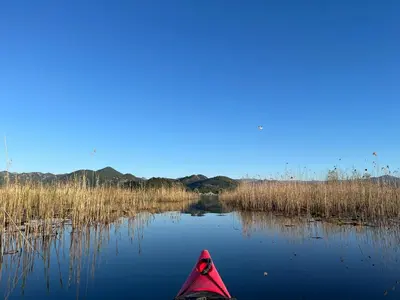 a red kayak on a river with grass and water at JG Studio apartment in Vranjina