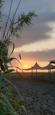 a sunset on the beach with a hammock at Meri in Bar