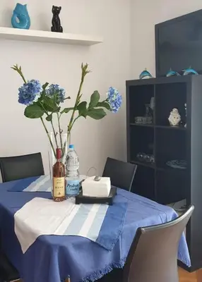a table with a blue table cloth and a vase of flowers at Meri in Bar