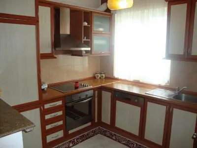 a kitchen with wooden cabinets and a sink and a stove at Firenze Apartments in Ulcinj