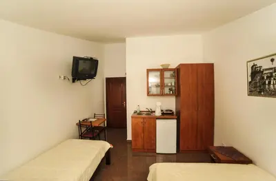 a small room with two beds and a television at Mijovic Apartments in Budva