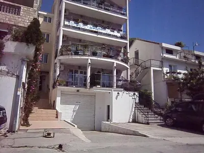an apartment building with a garage and a balcony at Mijovic Apartments in Budva
