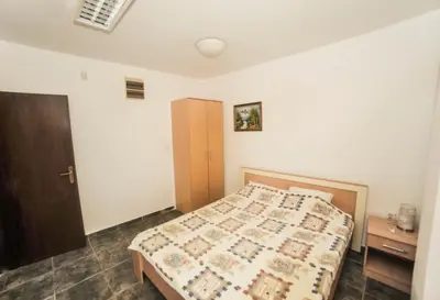 a bedroom with a bed and a wooden cabinet at Mijovic Apartments in Budva