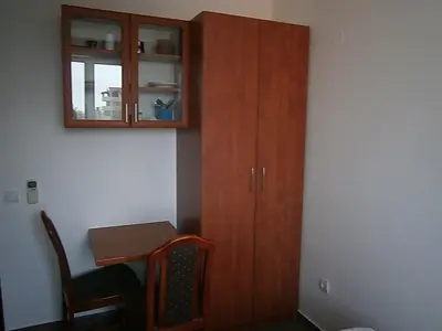 a kitchen with a wooden cabinet next to a table at Mijovic Apartments in Budva