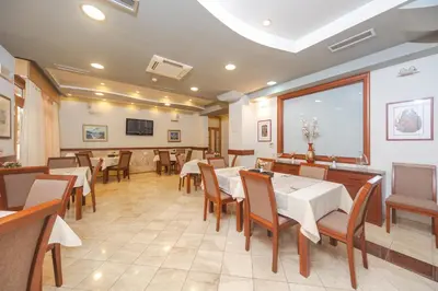 a restaurant with tables and chairs and a large window at Hotel Stella di Mare in Budva