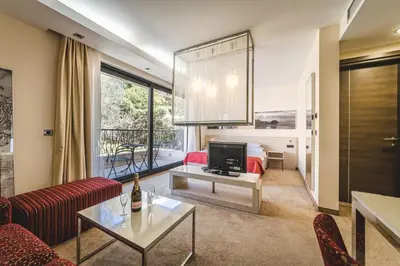 a living room with a couch a table and a tv at Hotel & Apartments HEC Residence in Sveti Stefan