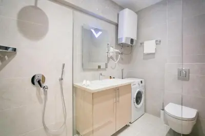 a bathroom with a sink and a washing machine at Apartments Lux in Budva