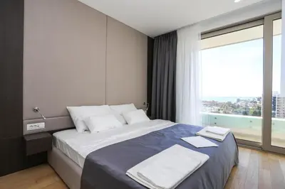 a bedroom with a large bed with a large window at Apartments Lux in Budva