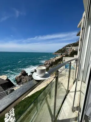 a cup of coffee sitting on a balcony overlooking the ocean at Paradise beachfront view 1 in Bar