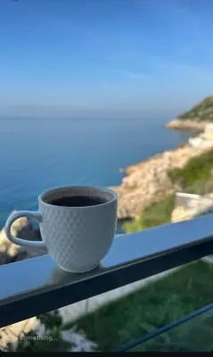 a cup of coffee sitting on a window sill at Paradise beachfront view 1 in Bar
