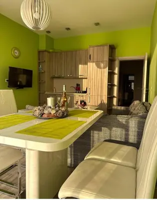 a kitchen with green walls and a table and chairs at Paradise beachfront view 1 in Bar