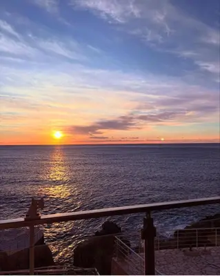 a sunset over the ocean with the sun setting at Paradise beachfront view 1 in Bar