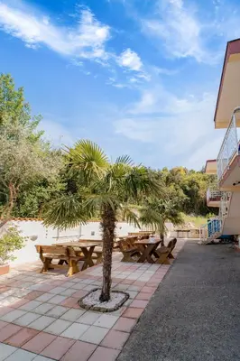 a picnic table and a palm tree in a patio at Villa Katharina in Utjeha