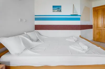 a white bed in a room with a striped wall at Villa Katharina in Utjeha