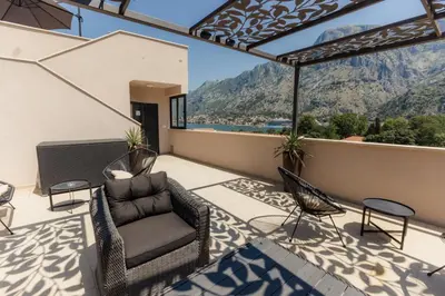 a patio with chairs and a couch on a balcony at Marea DeLuxe Apartments in Kotor