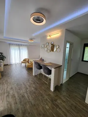 a living room with a table and chairs in it at Marea DeLuxe Apartments in Kotor