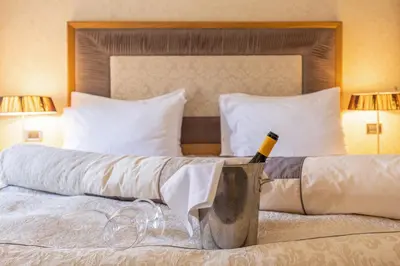 a bedroom with a bed with a bottle of wine at Hotel Vardar in Kotor