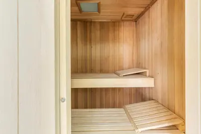 a sauna with wooden walls and wooden shelves at Hotel Vardar in Kotor