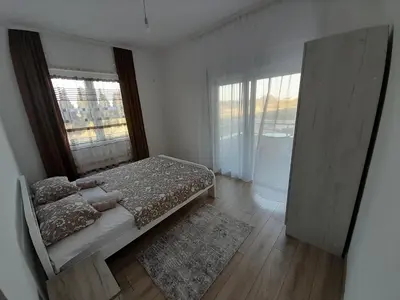 a bedroom with a bed and a large window at Apartment Long beach in Ulcinj
