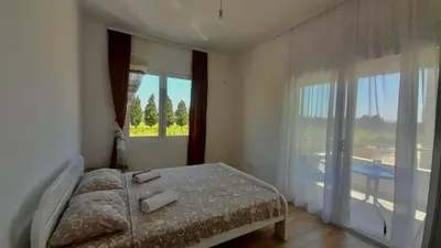 a bedroom with a bed and a large window at Apartment Long beach in Ulcinj