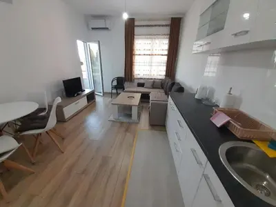 a kitchen with a sink and a living room at Apartment Long beach in Ulcinj