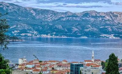 a town on the shore of a large body of water at Sea view Studio Terminal in Budva