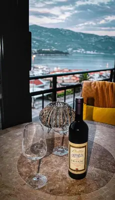 a bottle of wine and two glasses on a table at Sea view Studio Terminal in Budva
