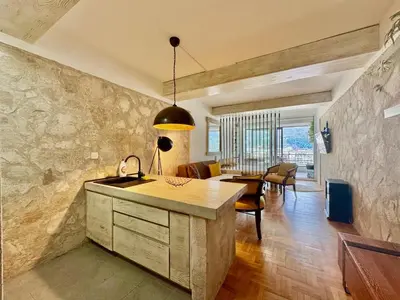 a kitchen and living room with a sink and a table at Sea view Studio Terminal in Budva